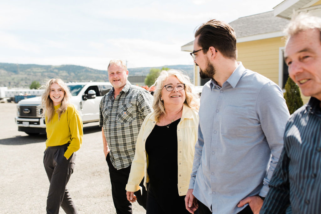 the ambler family who owns countryside manufactured homes walks outside the head office smiling and laughing with each other