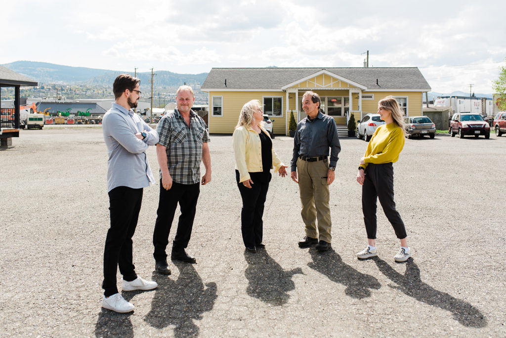 the team at countryside manufactured homes stands in the parking lot talking about what to expect when buying a modular home from them