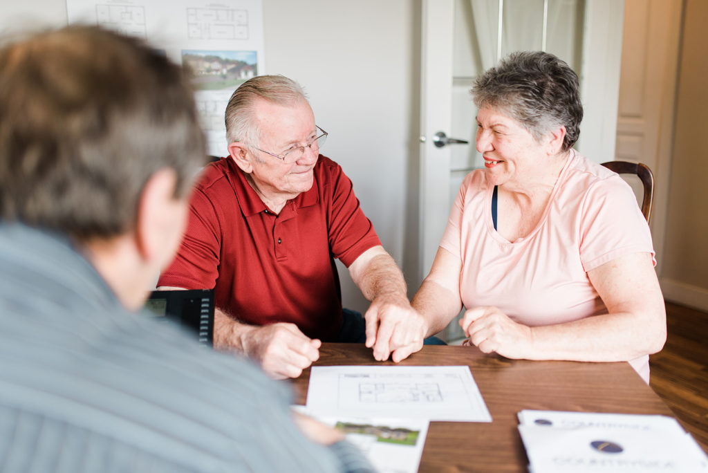 a retired couple looks at the differences between modular and manufactured homes with a countryside salesperson during the process of buying their manufactured home