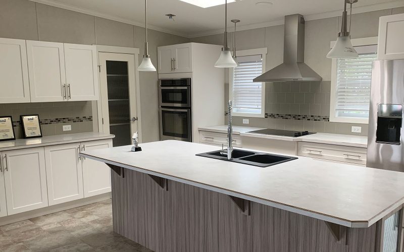 kitchen island, cupboards and appliances, white and grey, in this open concept look of the Kelowna showhome at countryside manufactured homes in Kamloops