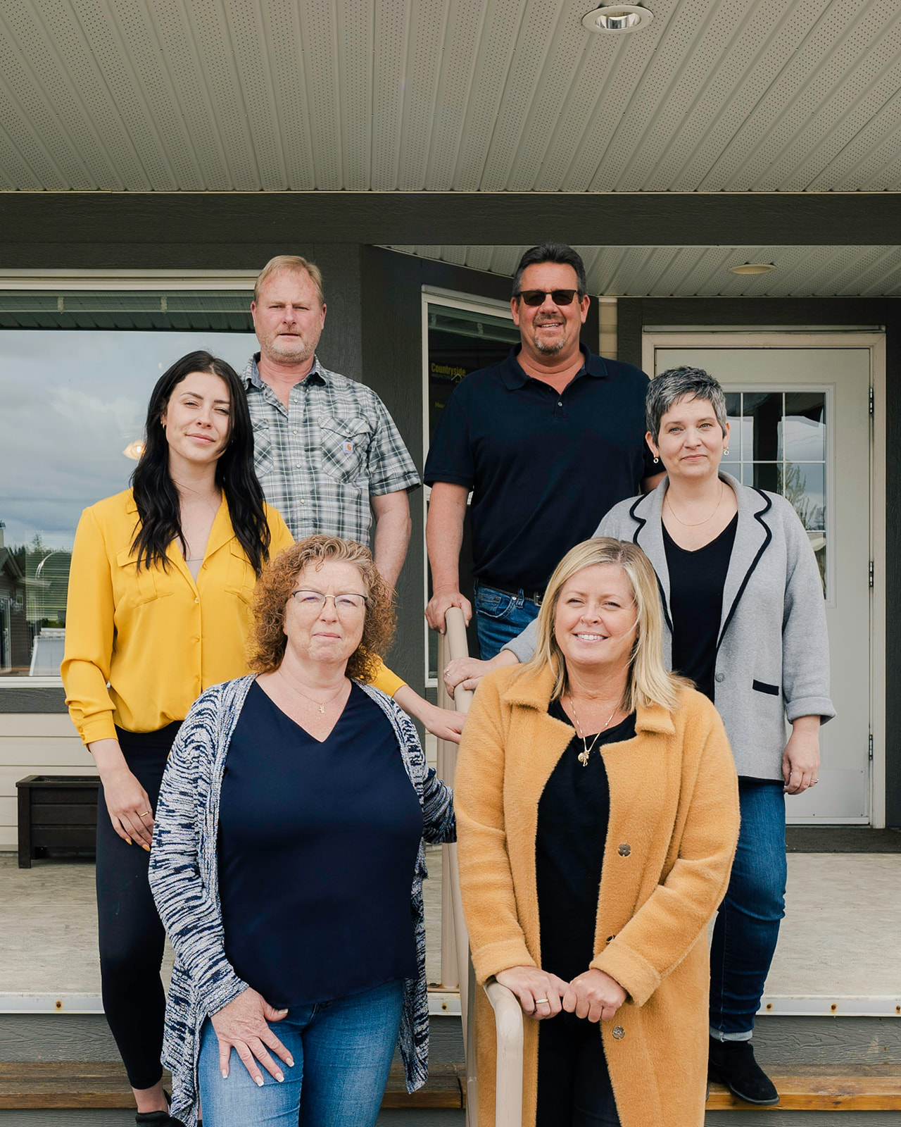 the countryside manufactured homes team in salmon arm stands on the porch of one of their showhomes