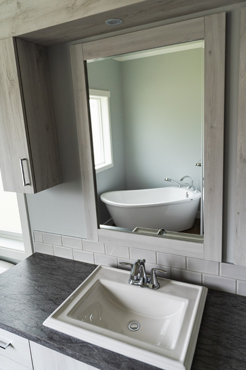 view of the bathroom and tub through a mirror in the kent showhome at countryside salmon arm