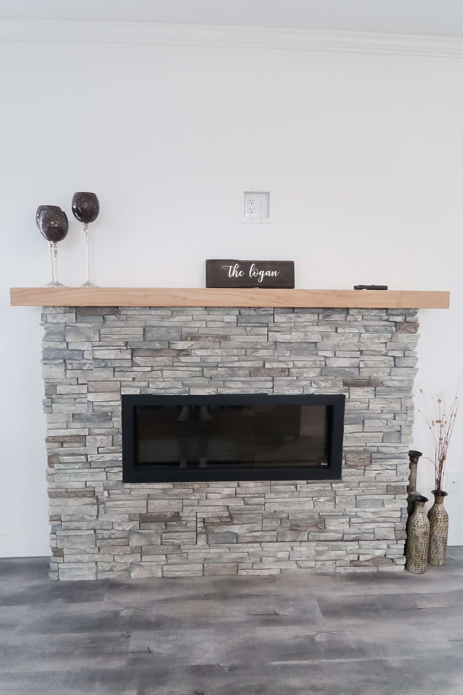 light rock tiled fireplace with wooden top in the logan showhome at countryside in kamloops