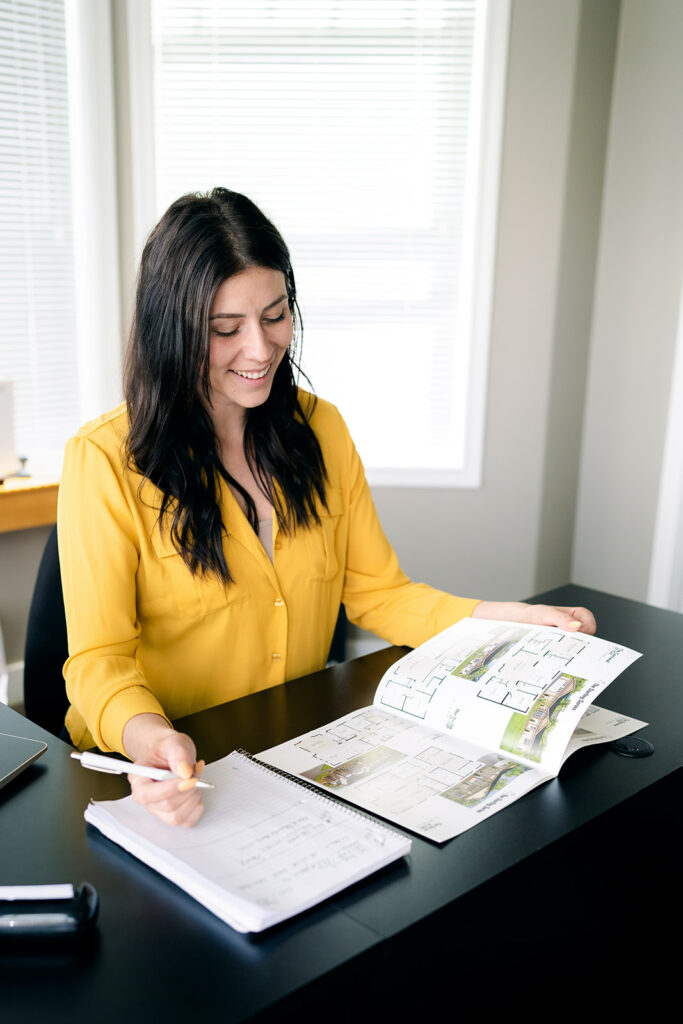 Home Design and Sales Advisor Britney browses a manufactured home magazine to help customers build their manufactured home in BC